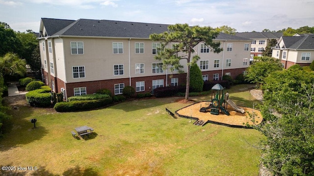 view of property's community featuring playground community, a residential view, and a lawn