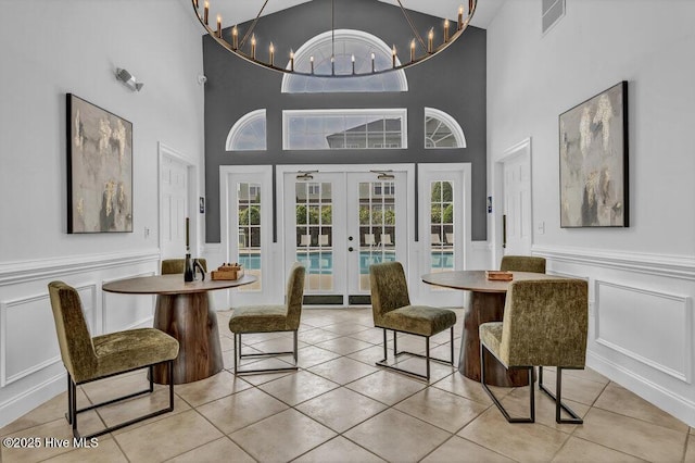 dining space featuring french doors, light tile patterned floors, a healthy amount of sunlight, visible vents, and a decorative wall