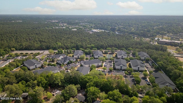 drone / aerial view with a wooded view and a residential view