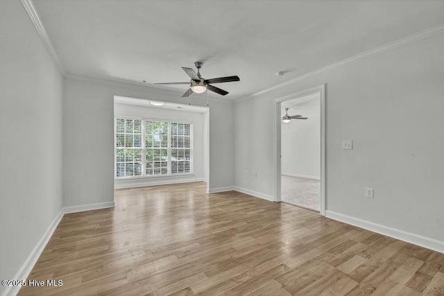 unfurnished room with ornamental molding, light wood-style flooring, baseboards, and ceiling fan