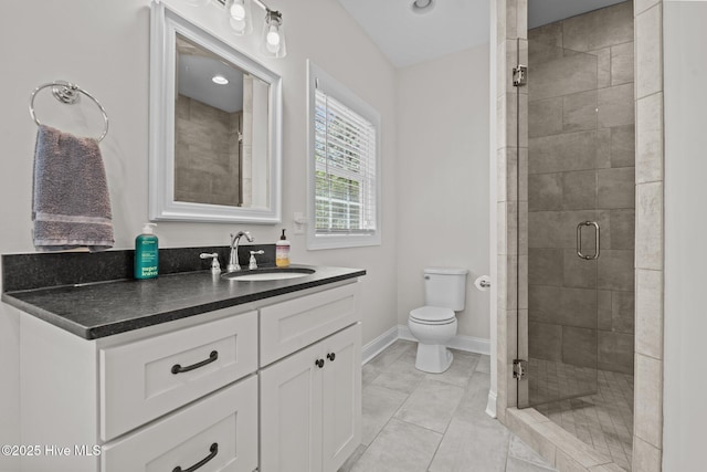 full bathroom featuring vanity, toilet, baseboards, tile patterned floors, and a stall shower