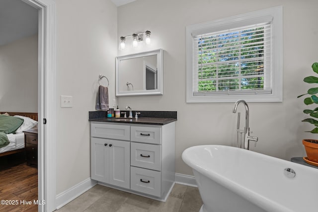 27 Pine Lake Dr, Whispering Pines, NC 28327 - ensuite bathroom featuring baseboards, vanity, and a freestanding tub