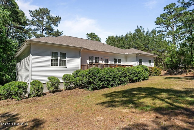 rear view of property with a lawn and a deck