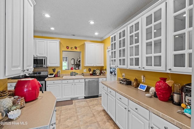 3332 Belt Rd, Castle Hayne, NC 28429 - kitchen featuring appliances with stainless steel finishes, white cabinets, light countertops, glass insert cabinets, and a sink