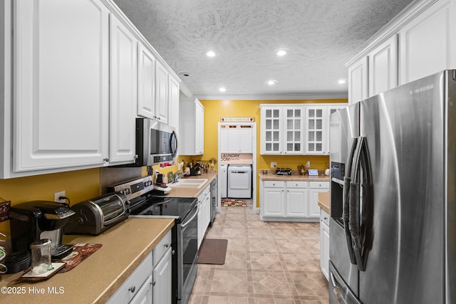 3332 Belt Rd, Castle Hayne, NC 28429 - kitchen with stainless steel appliances, washer / dryer, a sink, white cabinetry, and recessed lighting