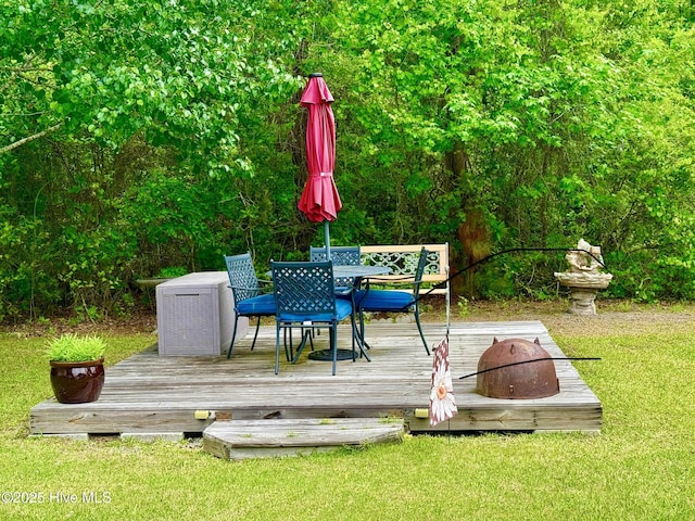 deck featuring a lawn and outdoor dining area