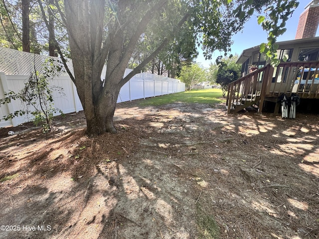 view of yard featuring a fenced backyard, a wooden deck, and stairway