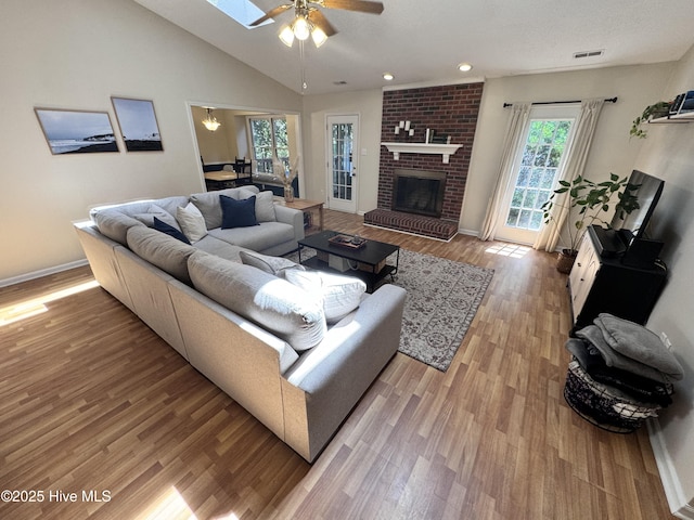 living area featuring light wood-style floors, a ceiling fan, and a wealth of natural light