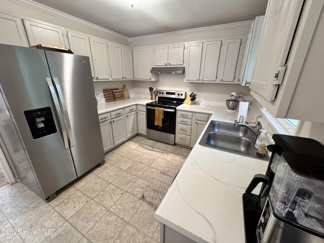 kitchen with light stone countertops, appliances with stainless steel finishes, a sink, under cabinet range hood, and ornamental molding