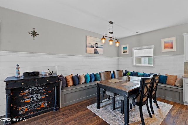 dining room featuring wainscoting, wood finished floors, and breakfast area