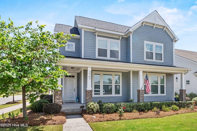 craftsman inspired home with roof with shingles and covered porch