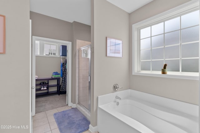 bathroom with healthy amount of natural light, a shower stall, and a bath