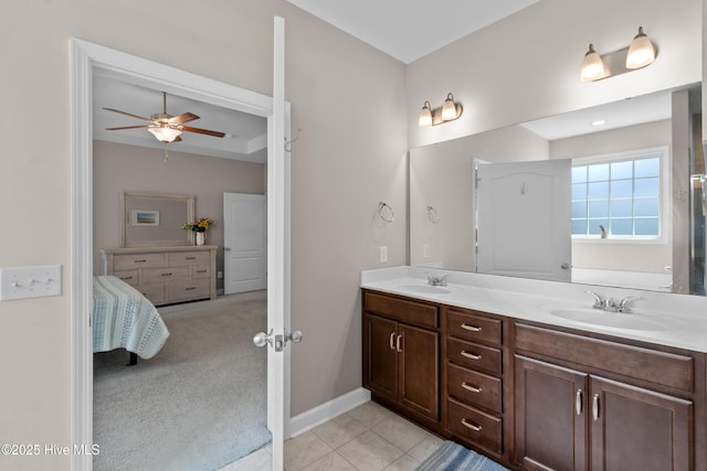full bathroom with a ceiling fan, double vanity, tile patterned flooring, and baseboards