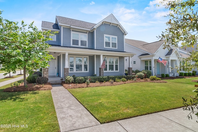 craftsman inspired home with covered porch, a front lawn, and roof with shingles