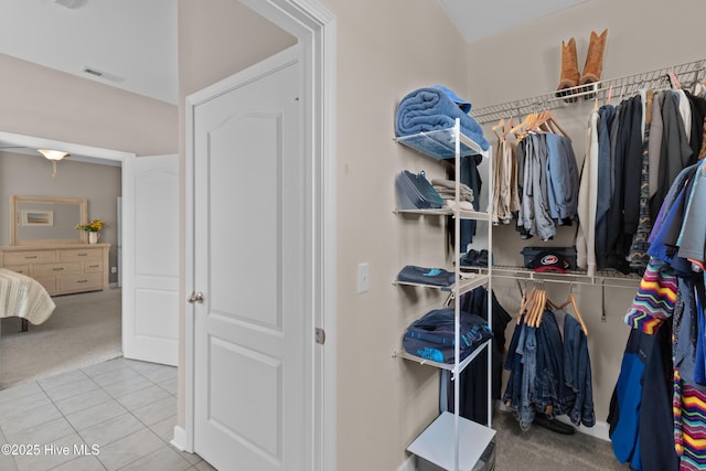 walk in closet featuring carpet floors and tile patterned flooring