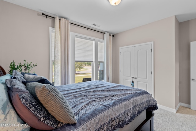 carpeted bedroom with a closet and baseboards