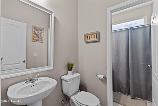 bathroom with a sink, toilet, and a shower with curtain