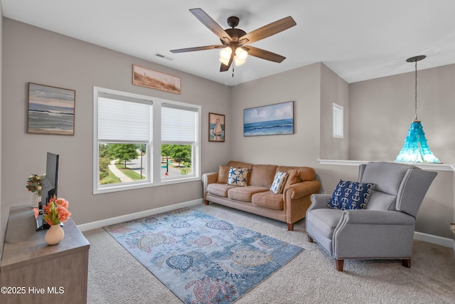 living area with carpet floors, baseboards, and ceiling fan