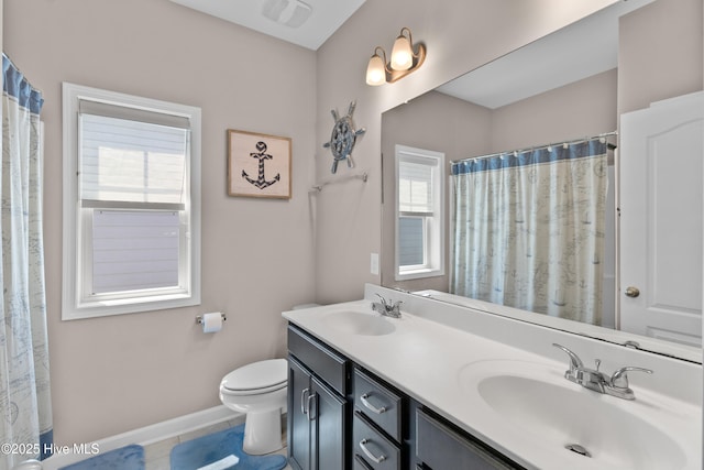 bathroom with toilet, tile patterned floors, double vanity, and baseboards