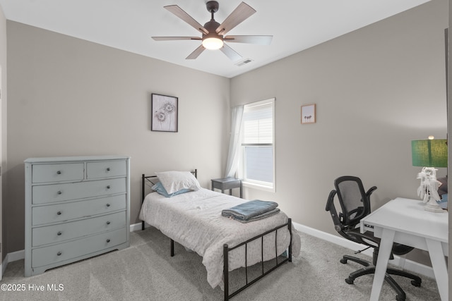 bedroom featuring light carpet, baseboards, a desk, and a ceiling fan
