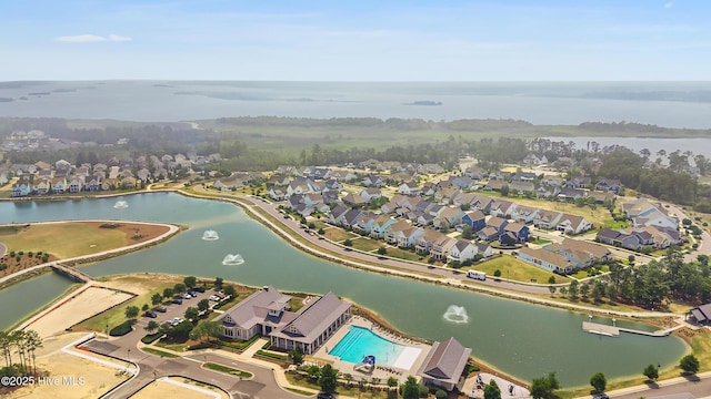 aerial overview of property's location featuring a nearby body of water, nearby suburban area, and a pool
