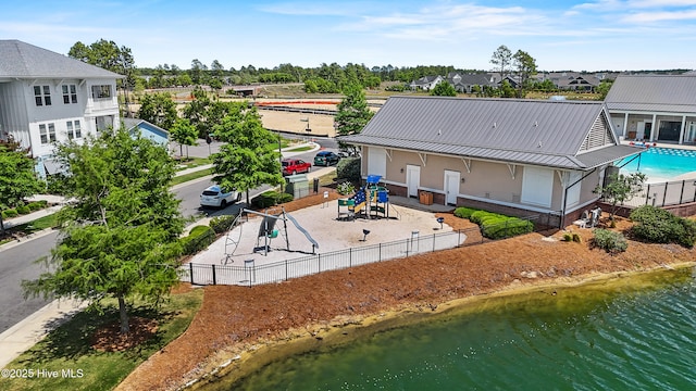aerial view of residential area with a pool area and a large body of water