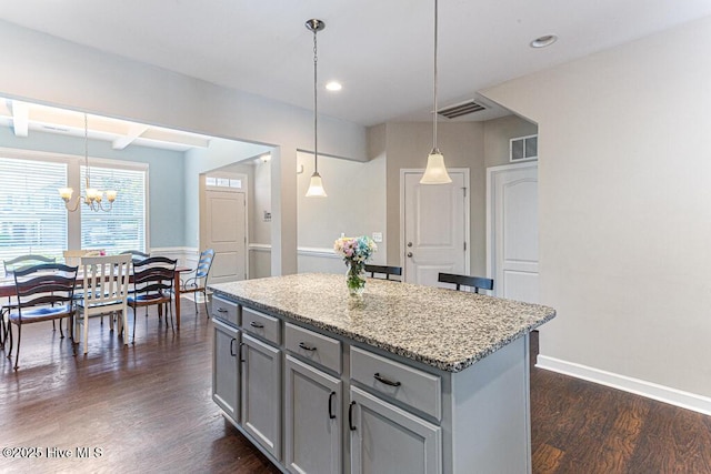 kitchen with a kitchen island, visible vents, dark wood finished floors, gray cabinetry, and an inviting chandelier