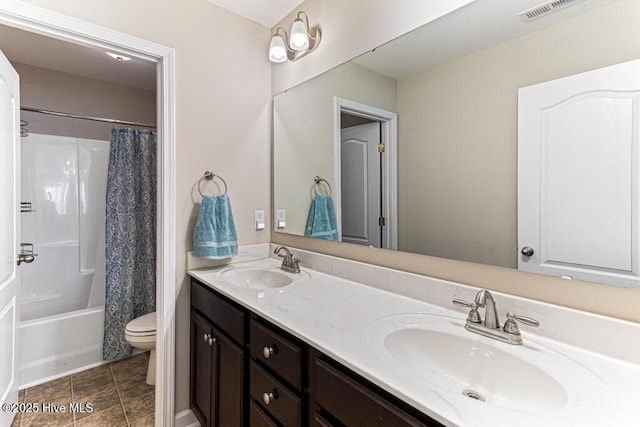 bathroom with a sink, toilet, double vanity, and visible vents