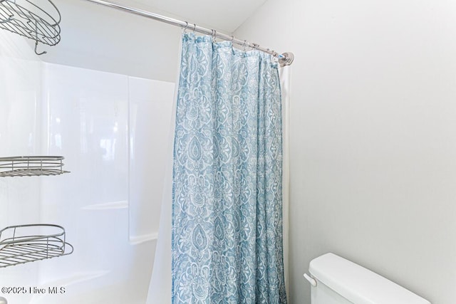bathroom with curtained shower and toilet