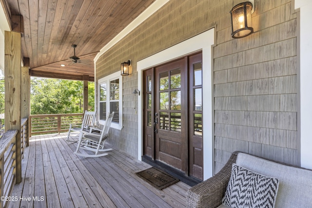 deck featuring covered porch, ceiling fan, and french doors