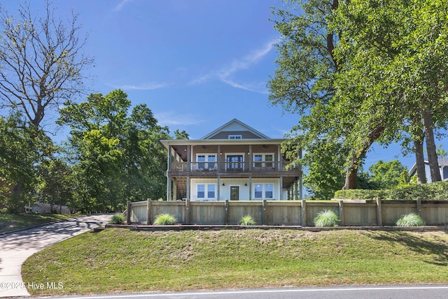 view of front of property featuring a fenced front yard, a balcony, and a front yard