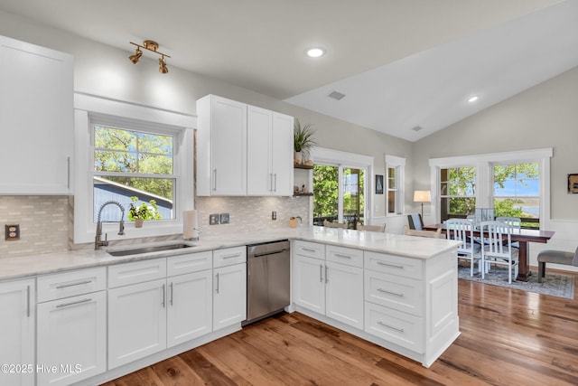 kitchen featuring stainless steel dishwasher, open shelves, a sink, white cabinets, and a peninsula