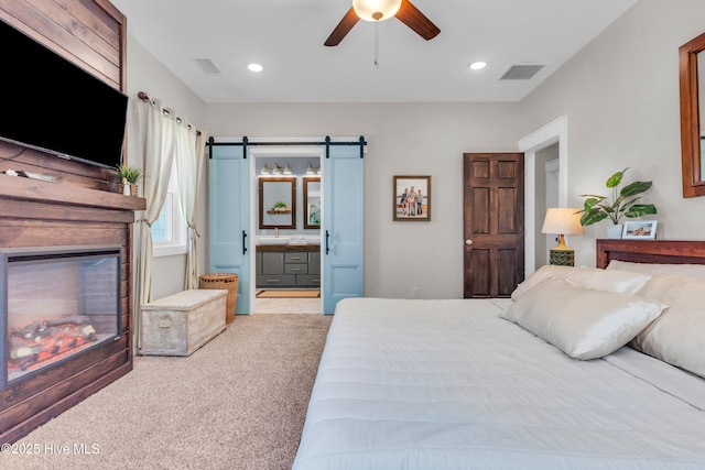 bedroom with recessed lighting, ensuite bath, a barn door, and visible vents