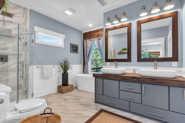 bathroom with a sink, a wainscoted wall, and a shower stall