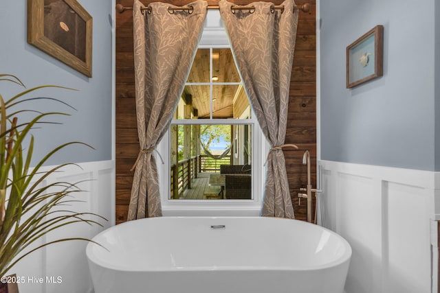 bathroom with a freestanding bath and wainscoting