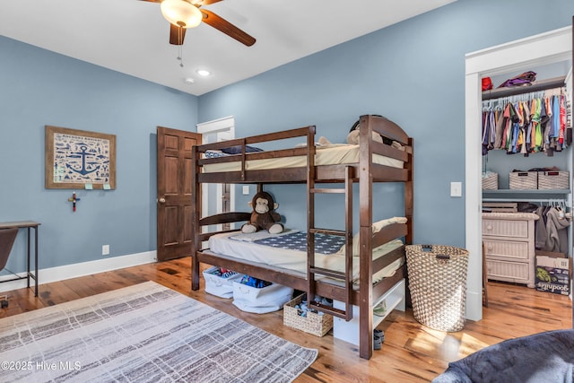 bedroom featuring ceiling fan, recessed lighting, baseboards, wood finished floors, and a closet