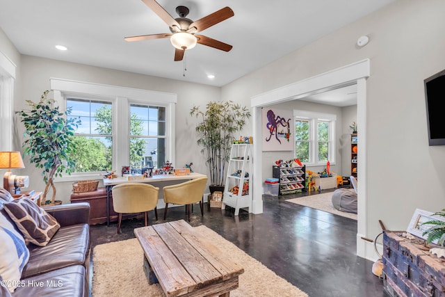 living area with concrete flooring, ceiling fan, and recessed lighting