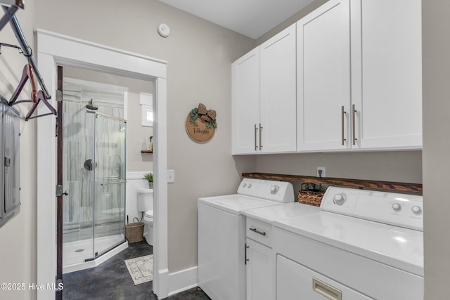 clothes washing area with baseboards, cabinet space, and washing machine and dryer