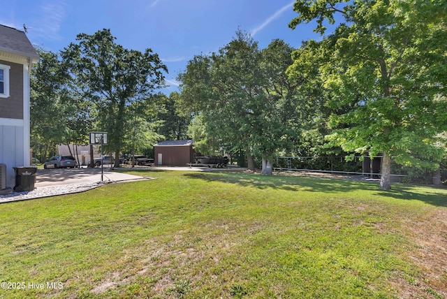 view of yard with fence, an outdoor structure, central AC, and a shed