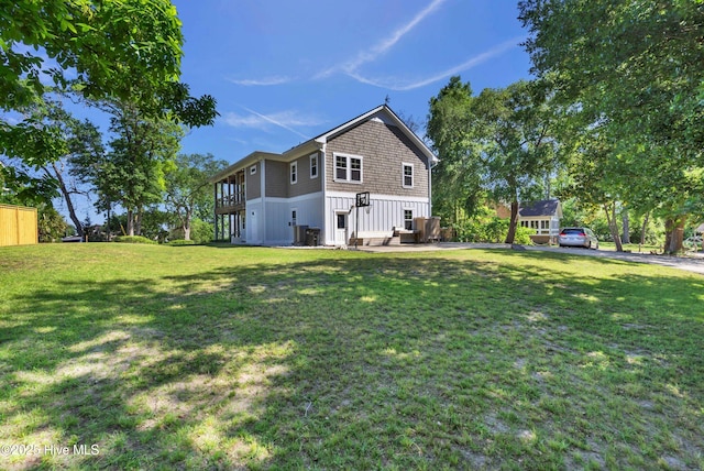 rear view of property featuring board and batten siding and a yard