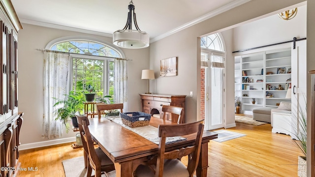 dining area with baseboards, ornamental molding, light wood finished floors, and a wealth of natural light