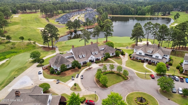 drone / aerial view with a water view and golf course view
