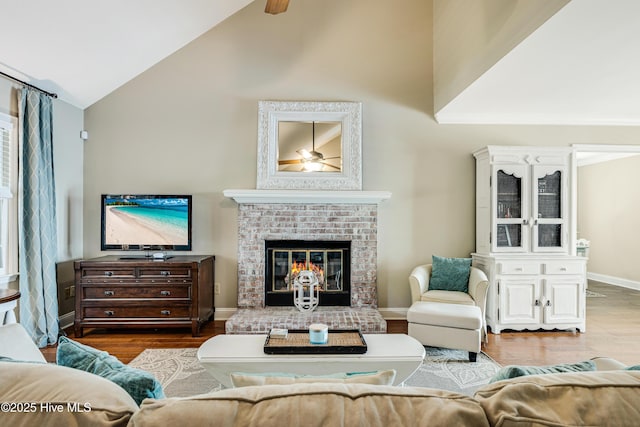 116 SE 20th St, Oak Island, NC 28465 - living room with a brick fireplace, wood finished floors, baseboards, high vaulted ceiling, and a ceiling fan