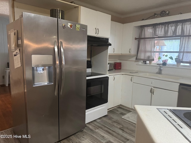 212 S Spence Ave, Goldsboro, NC 27534 - kitchen with appliances with stainless steel finishes, under cabinet range hood, crown molding, dark wood finished floors, and white cabinetry