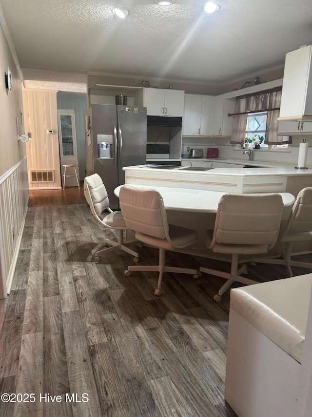 212 S Spence Ave, Goldsboro, NC 27534 - kitchen featuring stainless steel refrigerator with ice dispenser, dark wood-type flooring, light countertops, white cabinets, and a textured ceiling