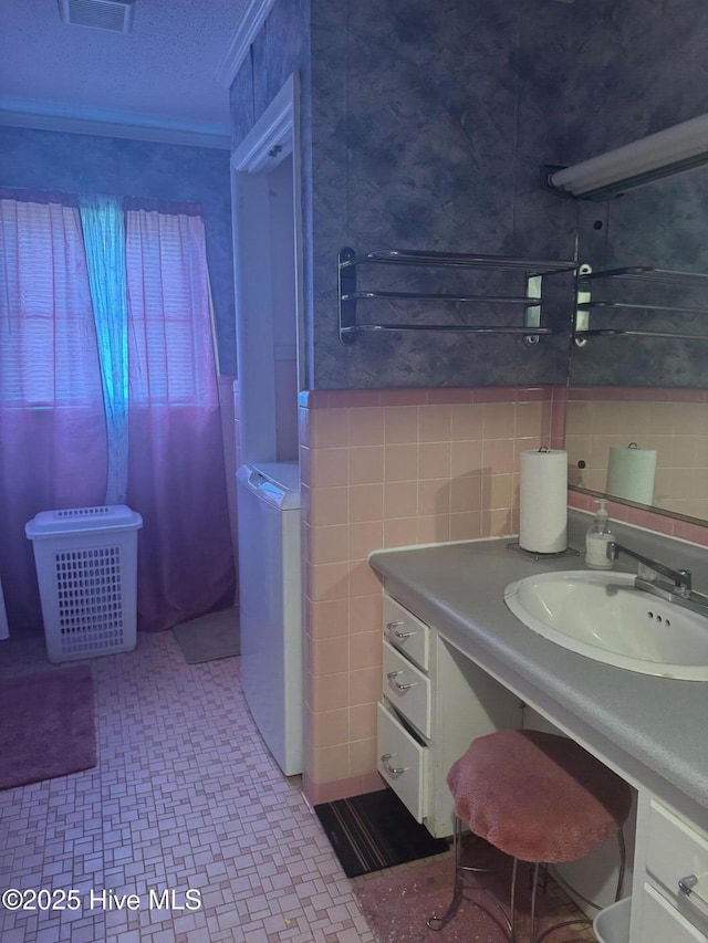 212 S Spence Ave, Goldsboro, NC 27534 - bathroom featuring tile patterned floors, washer / dryer, vanity, and tile walls
