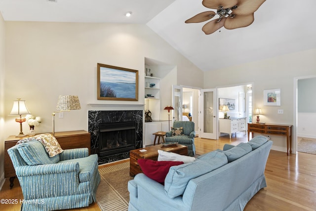 3733 Winstead Cir, Southport, NC 28461 - living room featuring light wood-style flooring, ceiling fan, a premium fireplace, and high vaulted ceiling