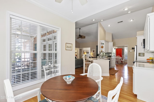 3733 Winstead Cir, Southport, NC 28461 - dining space featuring visible vents, light wood-style floors, ceiling fan, and high vaulted ceiling