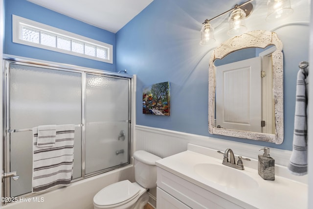 3733 Winstead Cir, Southport, NC 28461 - bathroom featuring a wainscoted wall, vanity, toilet, and shower / bath combination with glass door