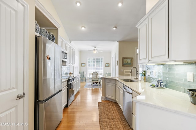 3733 Winstead Cir, Southport, NC 28461 - kitchen with ceiling fan, a sink, light wood finished floors, stainless steel appliances, and decorative backsplash